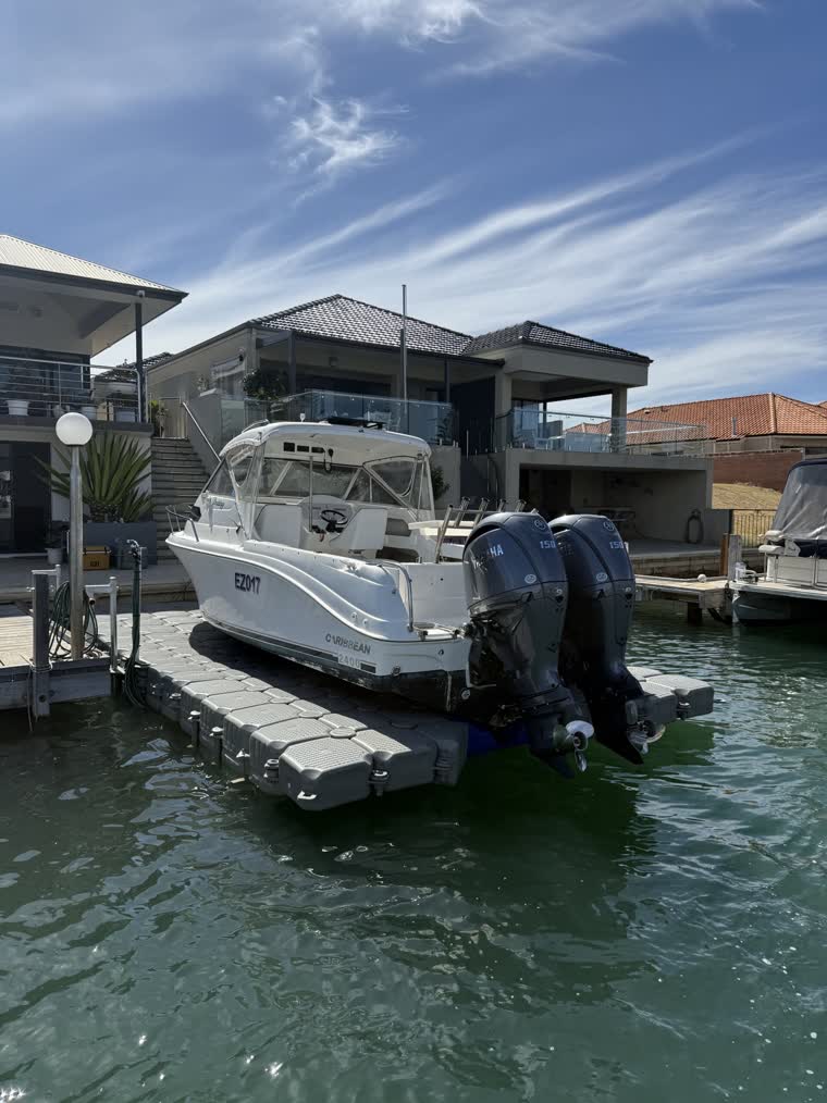 A photo shot from the back of a boat docked in front of a house