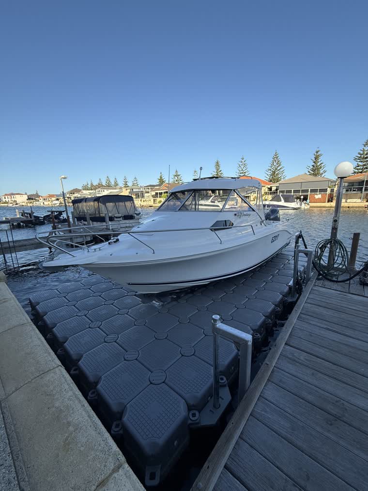 A boat docked under shade on a sunny day