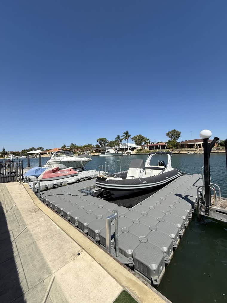 Boats and jetskis docked under the sun