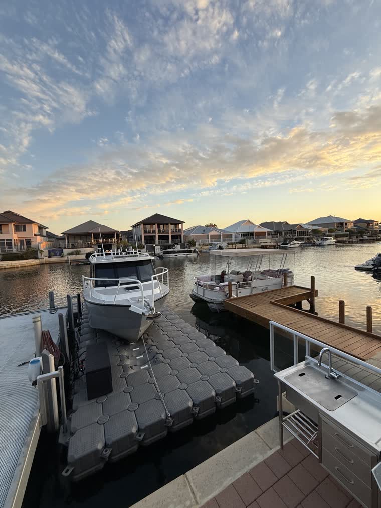 Front view of a docked boat on a partly cloudy day as the sun is setting