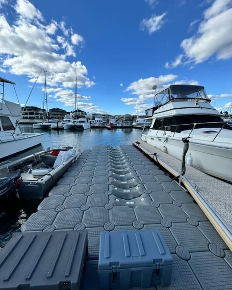 An empty dock with boats parked around and in the background