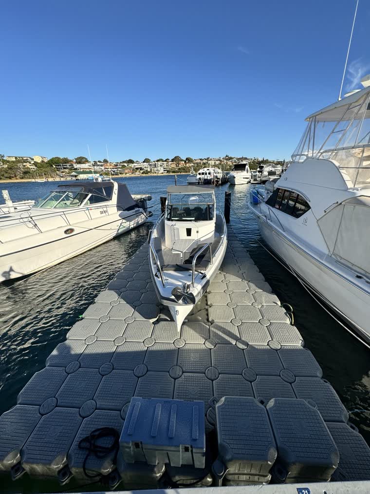 Front photo of a small boat on a dock under the sun