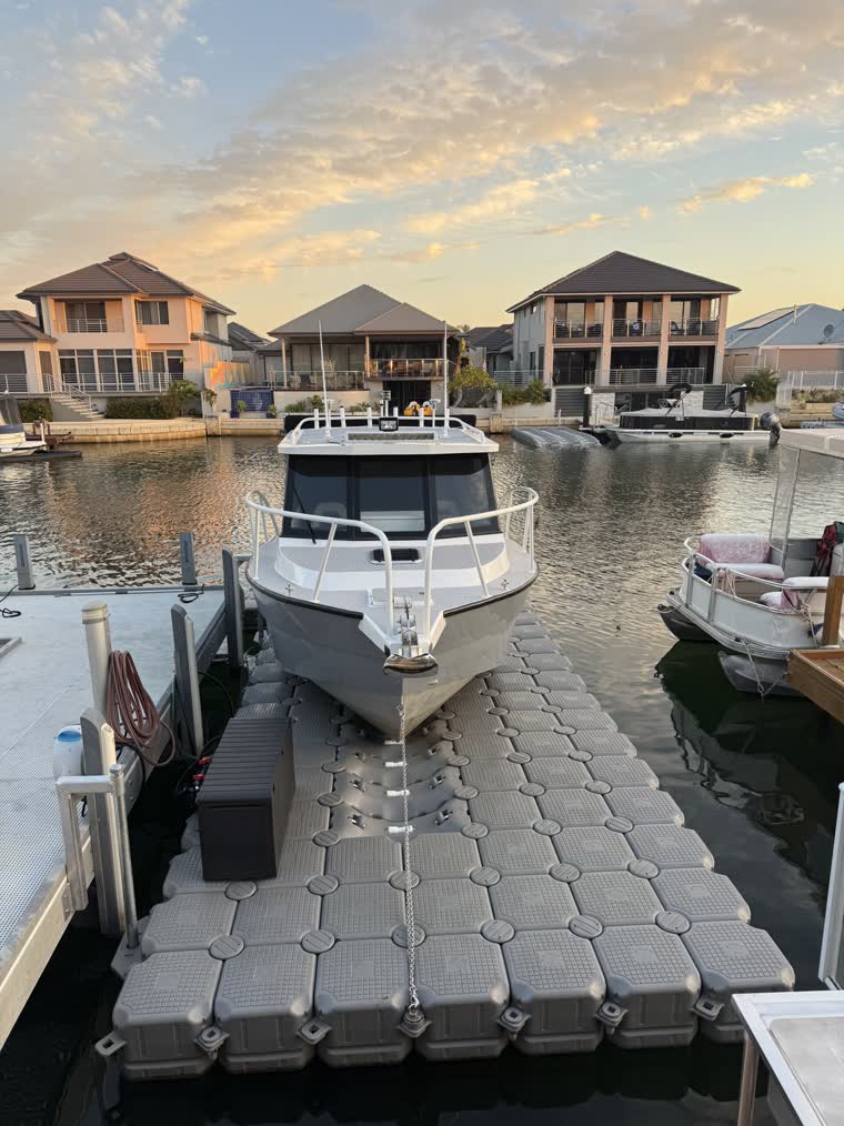 Front view of a docked boat on a partly cloudy day as the sun is setting