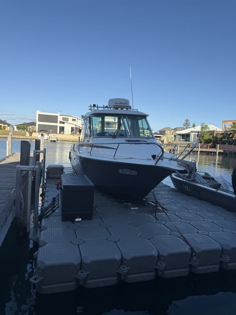 Front photo of a boat docked on a floating dock