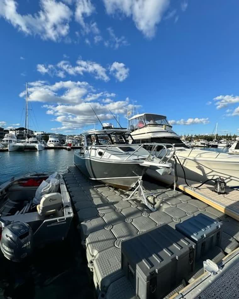 Image of boats attached to ropes onto a floating dock