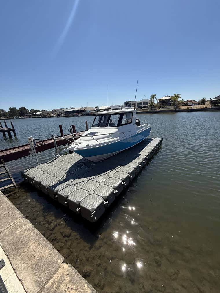Image of a boat docked on a floating dock on a sunny day
