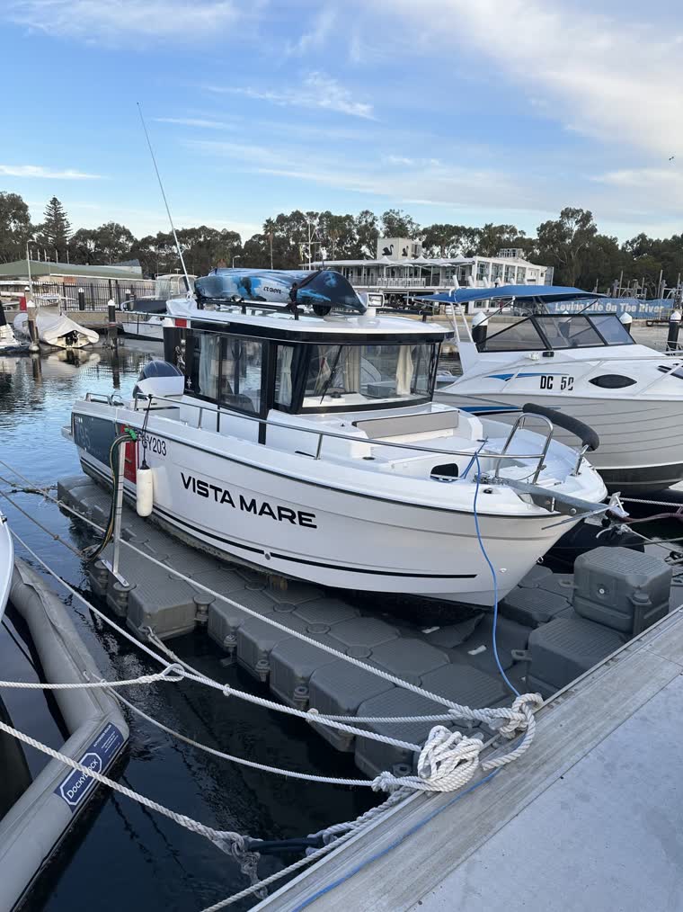 Large white boat docked on a floating dock