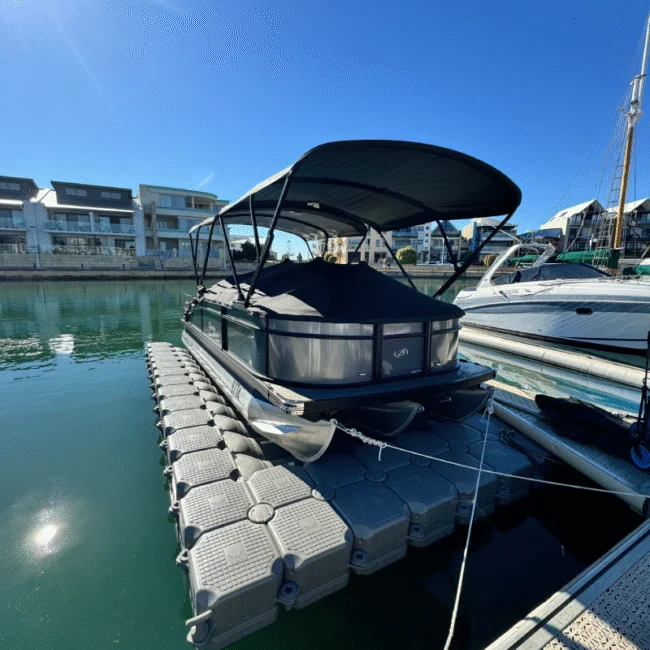 Luxury pontoon boat docked at a modern marina